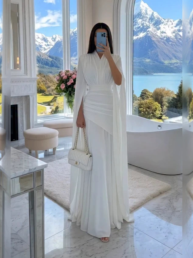 Rochie maxi albă, cu decolteu în V, mâneci tip capă, talie drapată și lungime până la podea