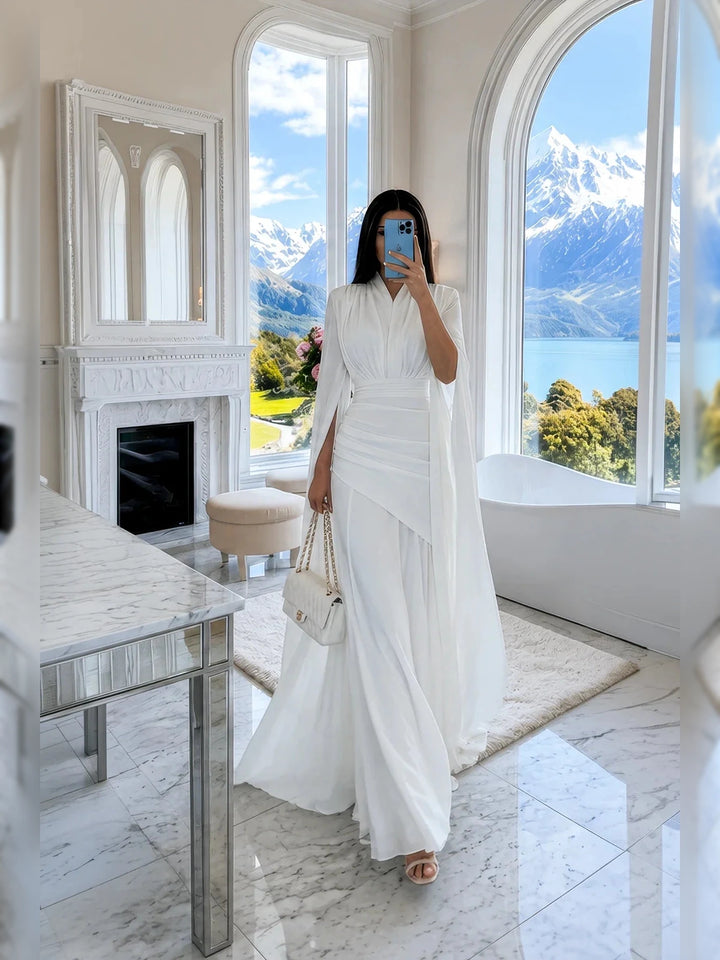 Rochie maxi albă, cu decolteu în V, mâneci tip capă, talie drapată și lungime până la podea