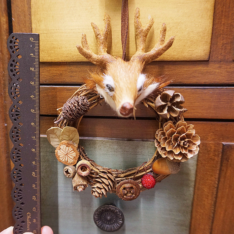 Świąteczna dekoracja wisząca z głową jelenia w kształcie szyszek