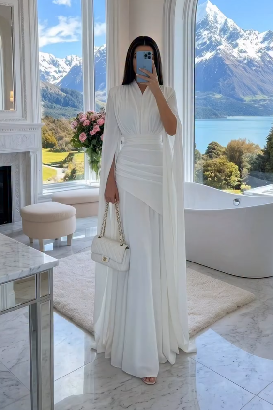 Rochie maxi albă, cu decolteu în V, mâneci tip capă, talie drapată și lungime până la podea